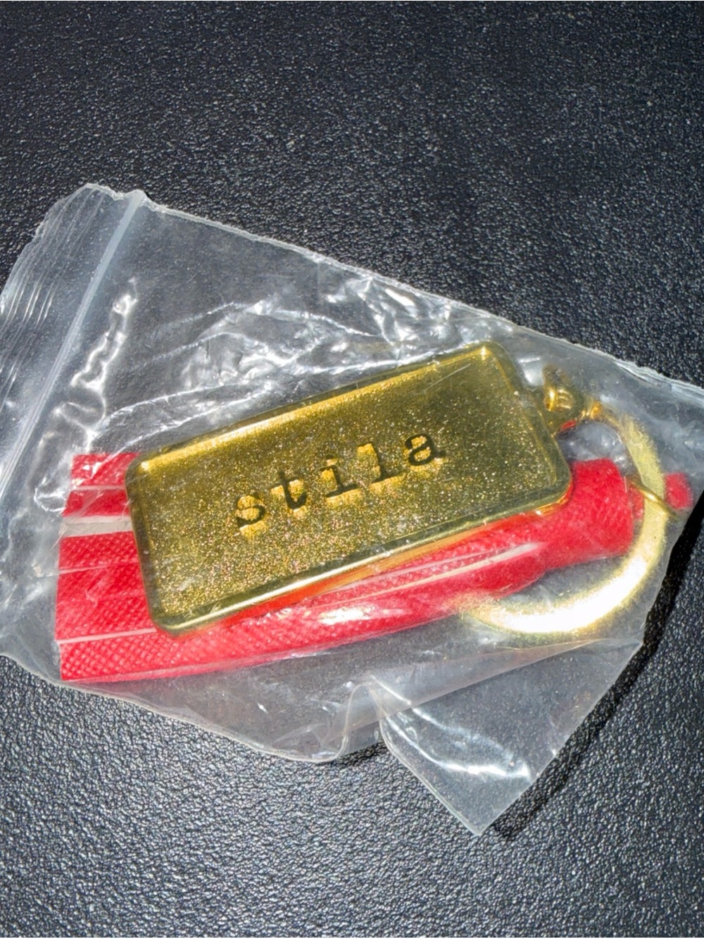 STILA Gold Tag Keychain with Red Tassel